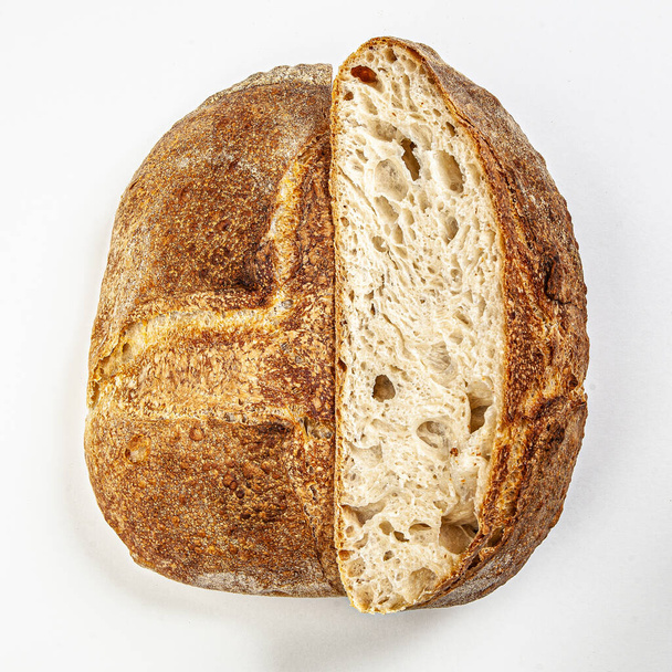 Hand made fresh bread cut in halfs isolated on white background. - Zdjęcie, obraz