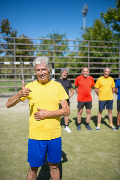 Портрет довольного пожилого человека на футбольном поле - Фото, изображение