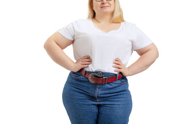 Cropped image of plus-size woman wearing white t-shirt and jeans posing isolated on white studio background. - Foto, Bild