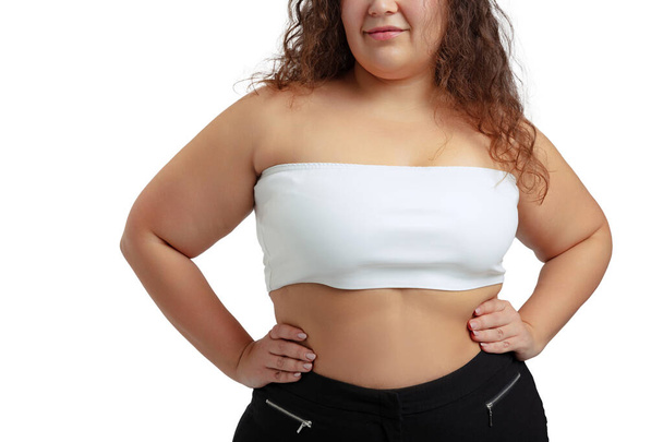 Cropped image of plus-size woman wearing white top and jeans posing isolated on white studio background. - Foto, Imagem