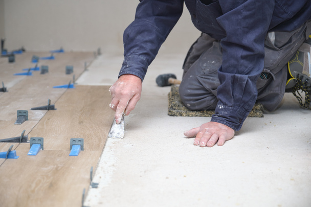 Unrecognizable senior mason laying ceramic wood effect tiles. - Foto, immagini