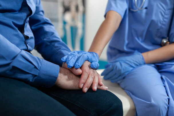 Close up of nurse holding hands of elder patient for support - Photo, Image