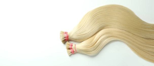 strengen van blond haar op witte achtergrond - Foto, afbeelding