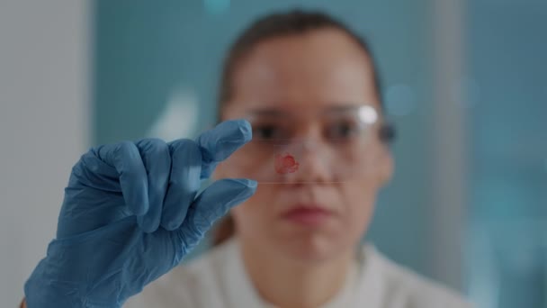 Женщина анализирует образец крови на подносе для лабораторного стекла - Кадры, видео
