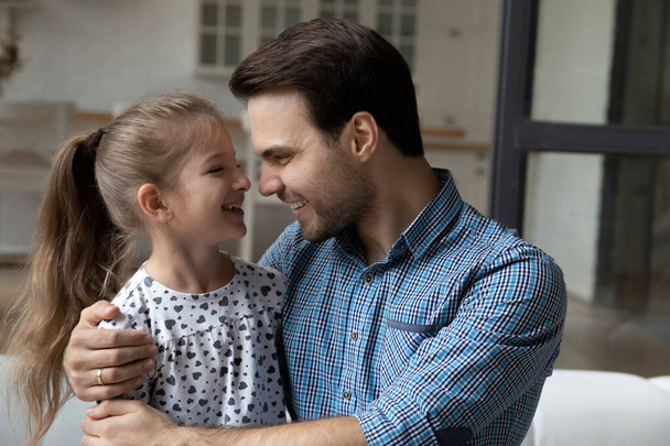 Close up loving smiling father hugging little daughter at home - Fotografie, Obrázek