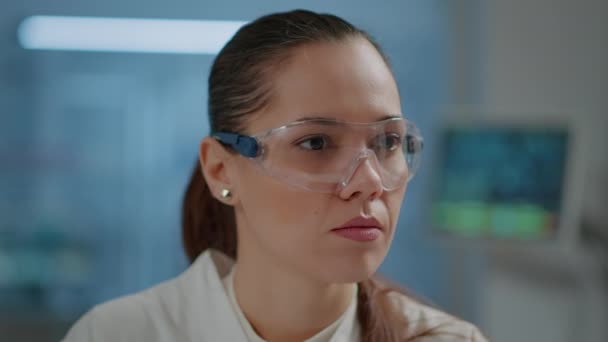 Donna scienziata con occhiali protettivi in laboratorio - Filmati, video