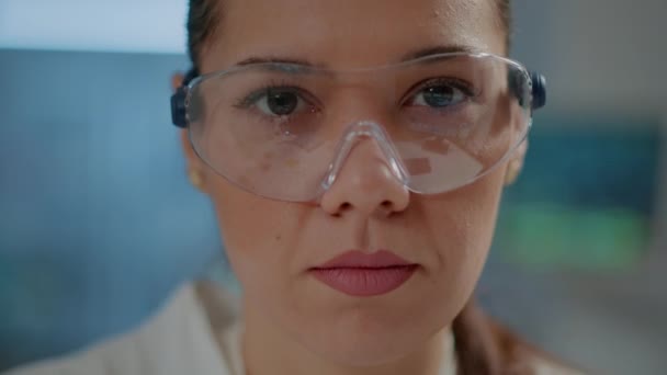 Biochemist with safety goggles and white coat in laboratory - Filmati, video