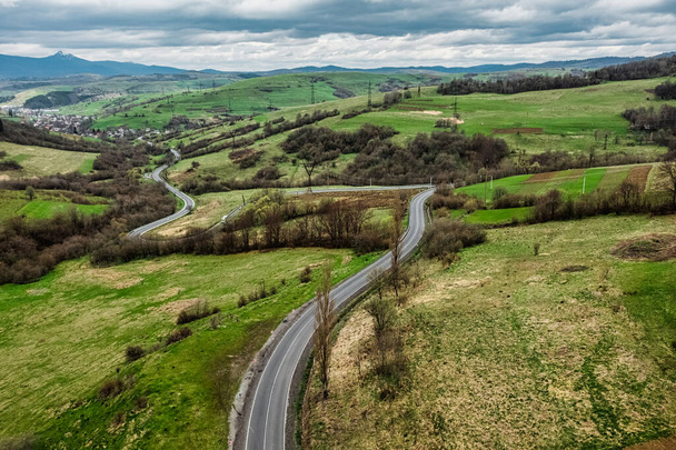 Aerial view of a narrow winding road, through the beautiful wooded Carpathians, amazing spring landscape, outdoor, tourist background, Transcarpathia, Ukraine - Photo, Image