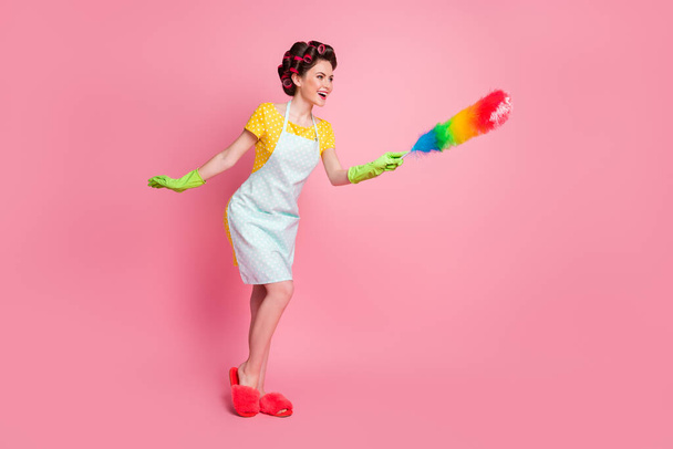 Full body photo of excited girl clean soft duster copyspace wear dotted dress gloves slippers isolated pastel color background - 写真・画像