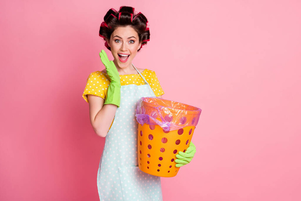 Portrait of nice attractive cheerful cheery glad brown-haired maid holding in hands trash basket isolated over pink pastel color background - Foto, Imagem