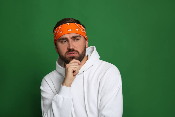Fashionable young man in stylish outfit with bandana on green background, space for text - Φωτογραφία, εικόνα