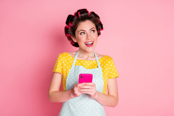 Close-up portrait of pretty cheerful dreamy creative maid using device app 5g creating idea comment isolated on pink pastel color background - Фото, изображение