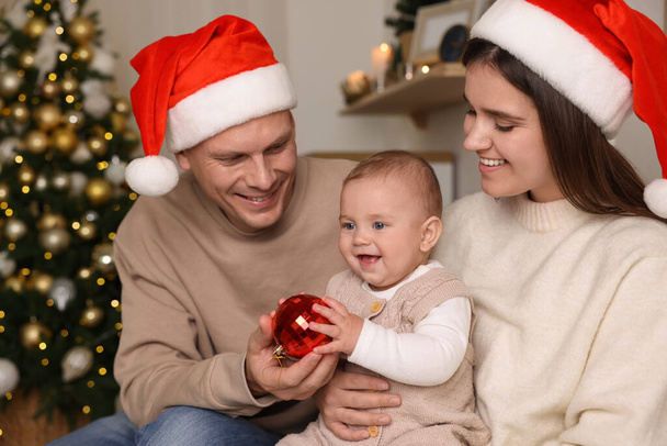 Happy couple with cute baby in room decorated for Christmas - Fotografie, Obrázek