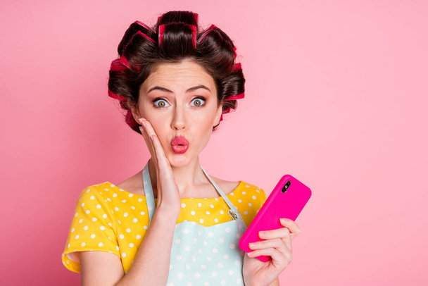 Primer plano retrato de glamoroso sorprendido criada blogger empleando gadget blogging reacción pucheros labios aislados en rosa pastel color fondo - Foto, Imagen