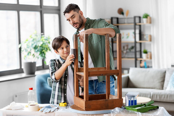 father and son sanding old table with sponge - Фото, изображение