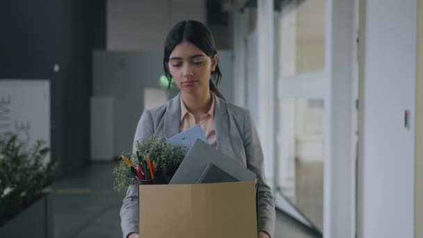 Einde carrière. Jonge ontslagen overstuur vrouw lopen door kantoorgebouw, het dragen van doos met persoonlijke bezittingen en huilen - Video