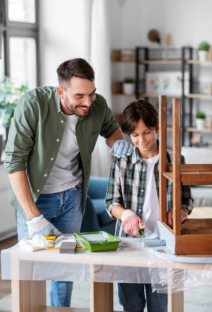 father and son painting old table in grey color - Foto, imagen