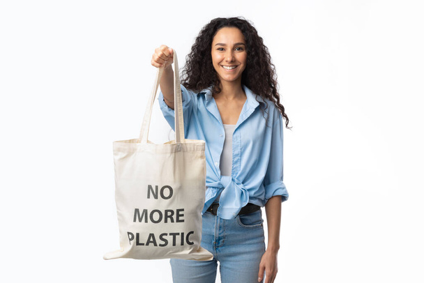 Donna sorridente che mostra Eco Shopper Bag con iscrizione, sfondo bianco - Foto, immagini
