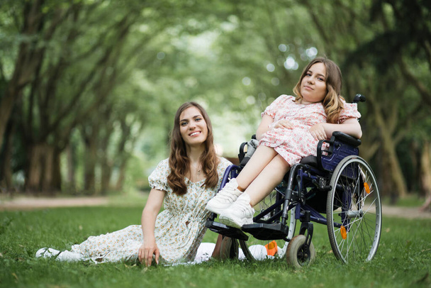 Woman and her disabled friend having picnic at park - Φωτογραφία, εικόνα
