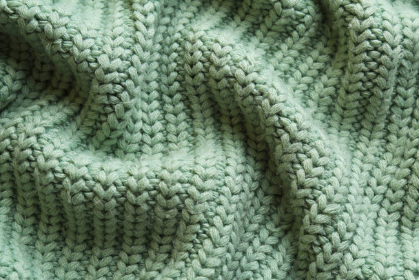 Beautiful pale green knitted fabric as background, top view - Фото, изображение
