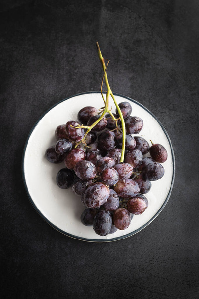 Plate with fresh red grapes - 写真・画像