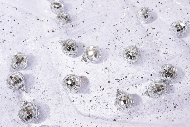 glanzende zilveren achtergrond met discoballen en glanzende stof met pailletten - Foto, afbeelding