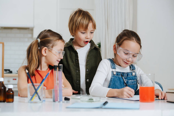 Happy little kids doing home science project, girl is documenting the process - Fotoğraf, Görsel