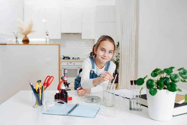 Elementary school age girl trying to do home science project. - Foto, immagini