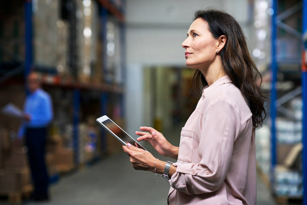 Caucasian woman working in the warehouse and holding digital tablet                                 - Foto, Bild