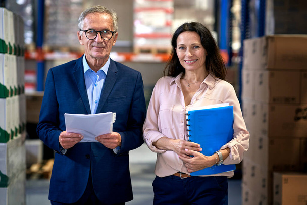 Portrait of caucasian business mature man and woman in the warehouse                                - Fotoğraf, Görsel