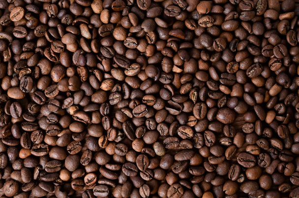 Kávové zrno pozadí. Pečená kávová zrna na dřevěném stole. Hnědá káva. Horní pohled - Fotografie, Obrázek