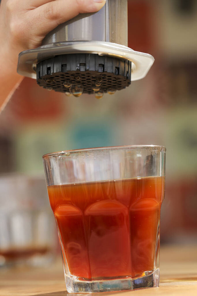 A vertical shot of a glass of fresh juice poured from a portable juicer - 写真・画像