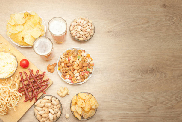 Chips, snacks, nuts mix, beer snack with the beer. Light background.  - Foto, immagini