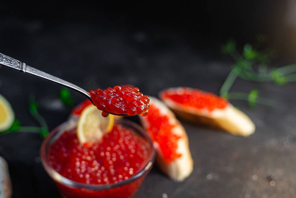Red caviar on a dark background. Sandwiches with caviar - Foto, Imagem