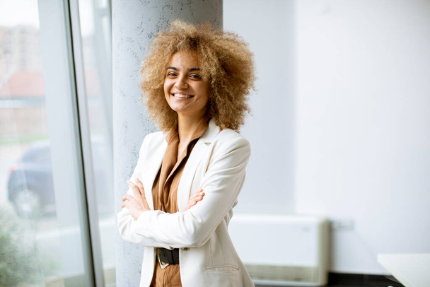Young African American businesswoman standing in the modern office - Фото, зображення