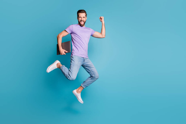 Full length body size photo of jumping high businessman with computer gesturing like winner smiling isolated on vivid blue color background - Fotoğraf, Görsel