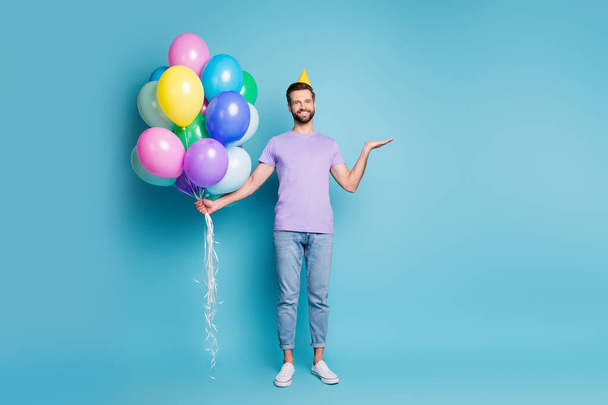 Full length body size photo of happy funny man colorful balloons keeping copyspace on hand smiling isolated on vivid blue color background - Fotoğraf, Görsel