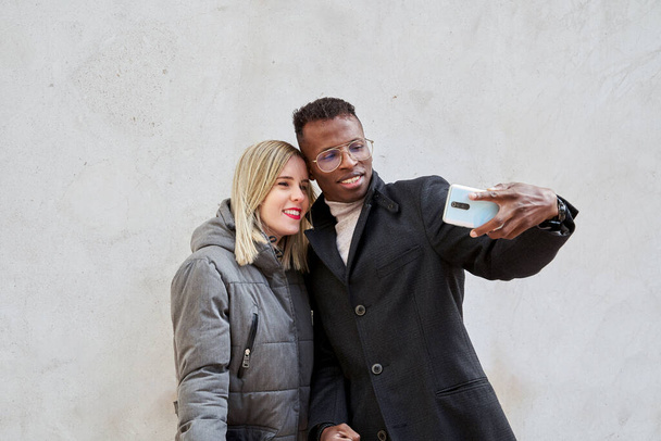 Couple multiracial prenant selfie dans la rue - Photo, image