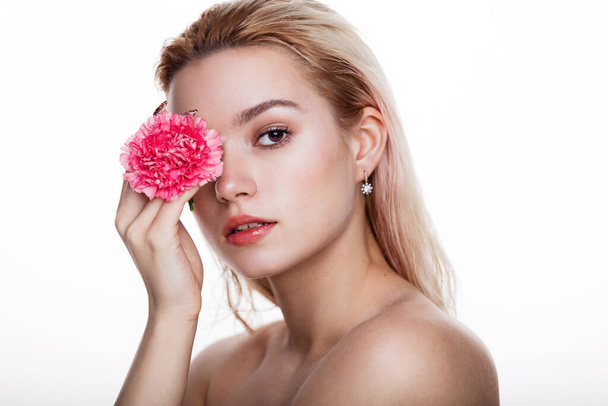 Viehättävä nuori nainen vaaleanpunainen kukka. Vaalea malli tilalla vaaleanpunainen kukka lähellä silmää eristetty valkoisella taustalla. Käsitys kauneuden ja terveydenhuollon vapaa tila tekstiä - Valokuva, kuva