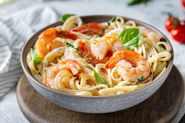 Pasta with shrimps and herbs in a plate on the table, close-up - Foto, afbeelding