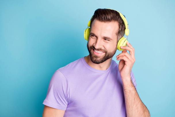 Photo portrait of funky happy student touching green headphones enjoying music smiling isolated on vivid blue color background - Foto, afbeelding