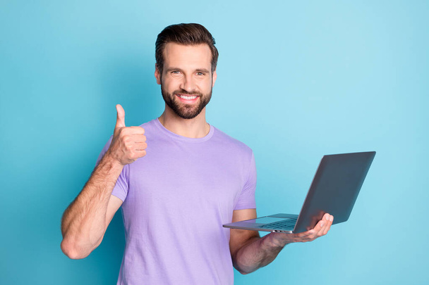 Photo portrait of smiling hipster keeping laptop showing like gesture doing project university isolated bright blue color background - Valokuva, kuva