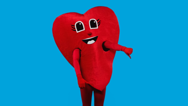 személy piros szív jelmez mutatja hüvelykujját le elszigetelt kék  - Fotó, kép