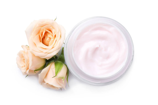 Jar of body cream with rose flowers on white background, top view - Foto, Bild