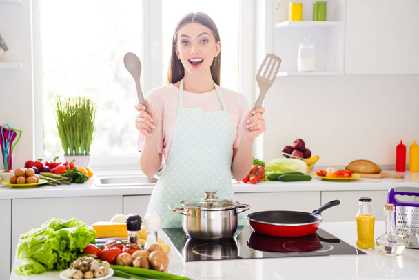 Portrait of attractive cheerful girl cooking fresh meal homemade salad cuisine enjoying learning at home light white kitchen indoors - Photo, Image