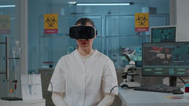 Químico trabajando con auriculares de realidad virtual en laboratorio - Metraje, vídeo
