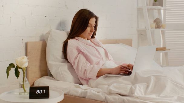 Brunetka kobieta za pomocą laptopa w łóżku w domu  - Zdjęcie, obraz