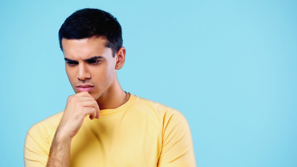 pensive young man in yellow t-shirt thinking isolated on blue - Fotoğraf, Görsel