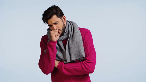 άρρωστος άνδρας με ροζ πουλόβερ και μαντήλι βήχει απομονωμένος στο μπλε  - Φωτογραφία, εικόνα