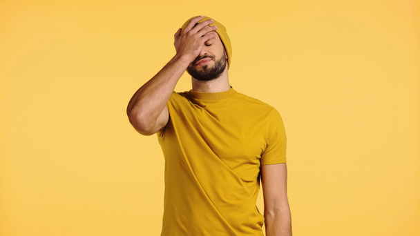 young man in beanie hat showing face palm isolated on yellow - Fotoğraf, Görsel